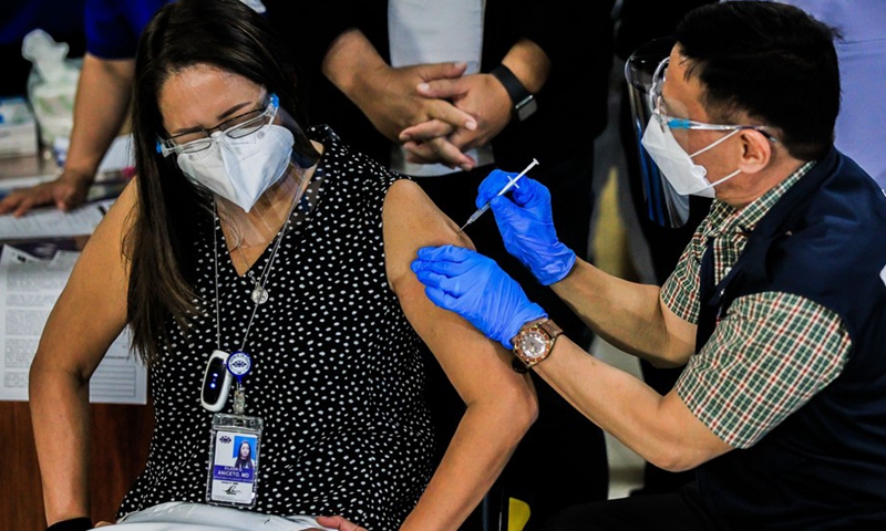 Philippine Department of Health Secretary Francisco Duque III injects a shot of COVID-19 vaccine from China's Sinovac to a doctor on the first day of the vaccination at the Lung Center of the Philippines in Manila, the Philippines on March 1, 2021. (Photo: Xinhua)
