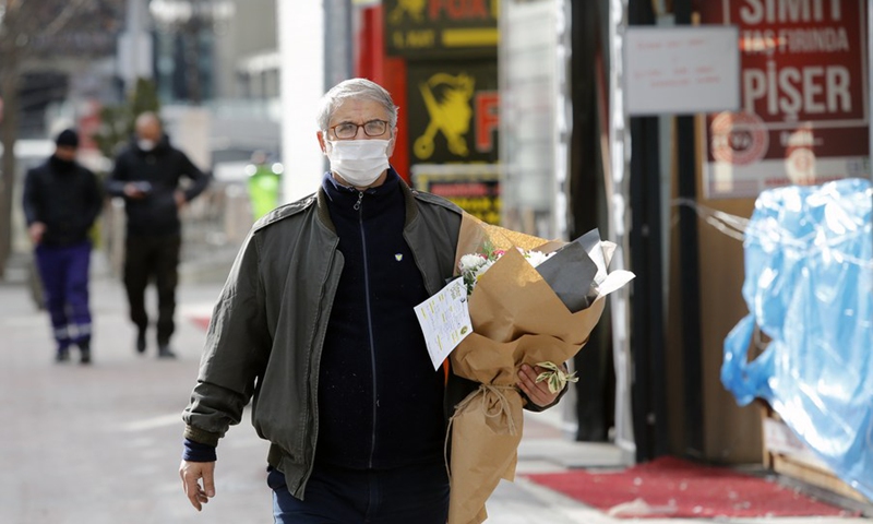 A man wearing a mask carries a bouquet of flowers in Ankara, Turkey, on Feb. 14, 2021, Valentine's Day.(Photo: Xinhua)