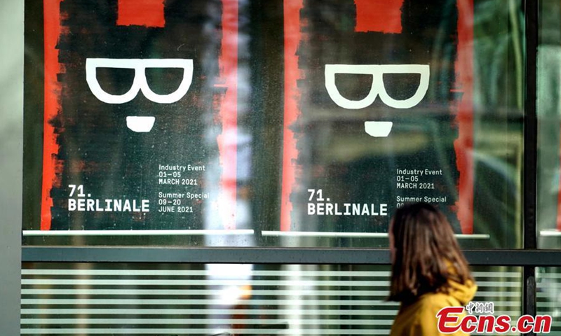 A woman passes by a poster for the 71st Berlin International Film Festival in Berlin, Germany.Photo:China News Service