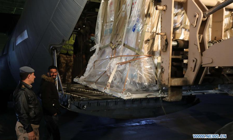 Staff members unload the COVID-19 vaccines donated by China at an airbase in Baghdad, Iraq, March 2, 2021. Iraq received a shipment of China's COVID-19 vaccines on Tuesday.Photo:Xinhua