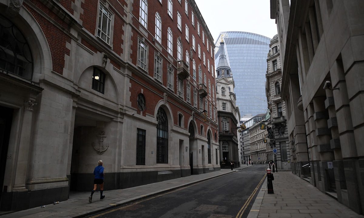 Pedestrians walk along a near-deserted street in London on Tuesday, as 20 Fenchurch Street, commonly known as the 