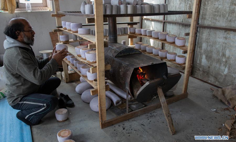 A worker dries a papier mache craft at a workshop in the downtown area of Srinagar city, the summer capital of Indian-controlled Kashmir, March 1, 2021. Papier mache is an art of moulding paper and flour and later sculpting it to create different crafts.(Photo: Xinhua)