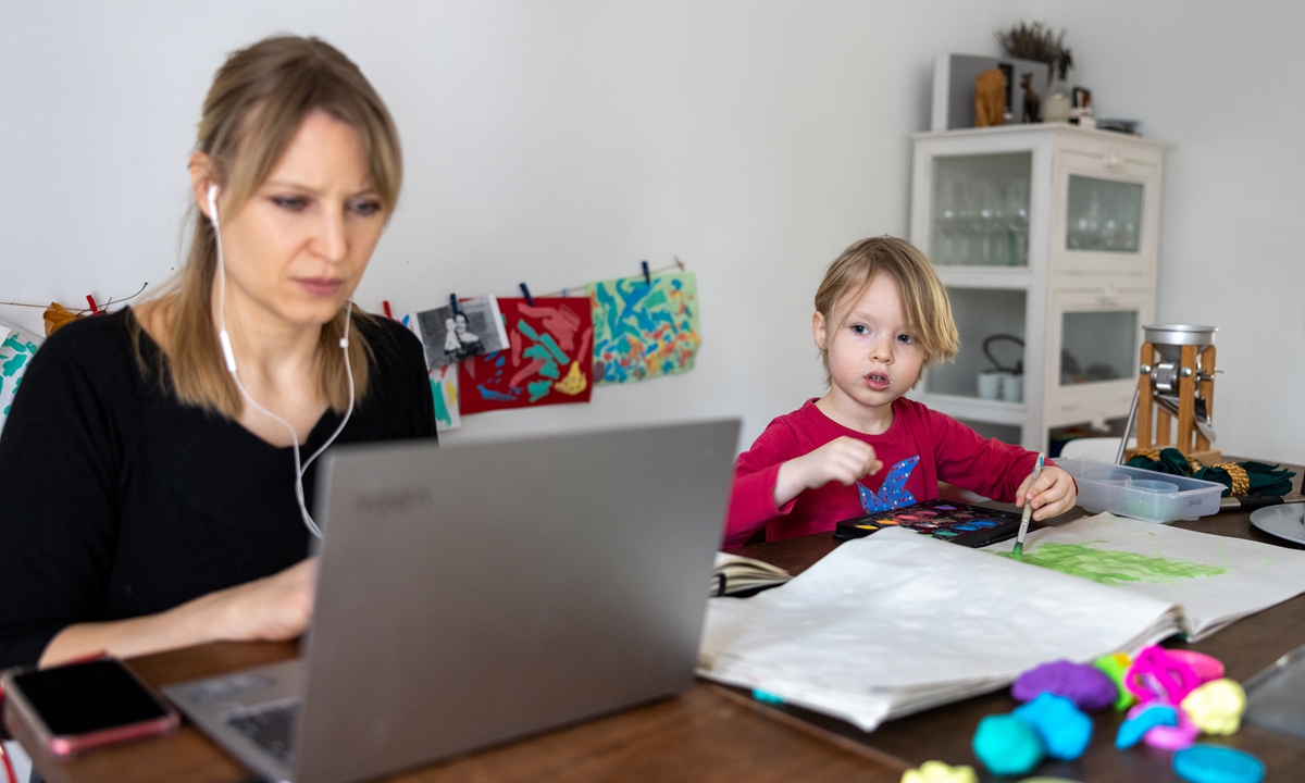 A son paints while his mother works and attends a digital conference at home in Zehlendorf district during the second wave of the coronavirus pandemic on February 18, 2021 in Berlin, Germany. Photo: VCG