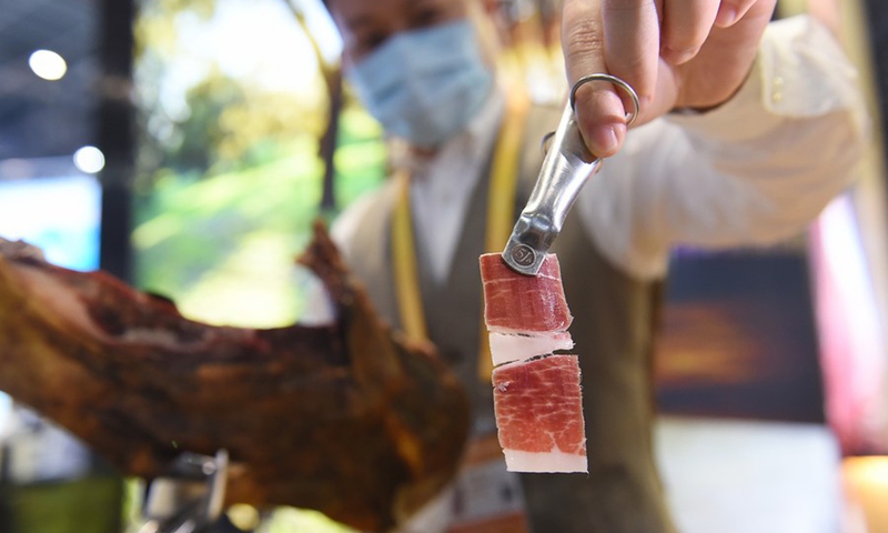 An exhibitor shows a slice of ham from Spain at the Food and Agricultural Products exhibition area during the third China International Import Expo (CIIE) in Shanghai, east China, Nov. 7, 2020.(Photo: Xinhua)