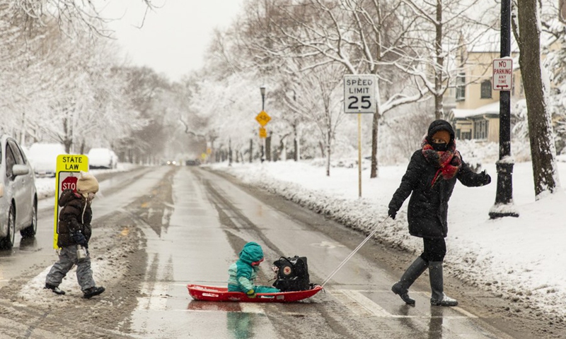 A woman and her children cross a road in Evanston, north of Chicago, Illinois, the United States, on Jan. 26, 2021.(Photo: Xinhua)