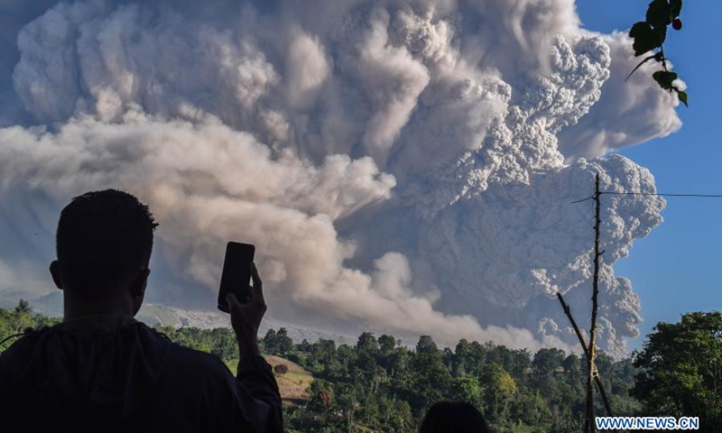 A man uses his cellphone to capture volcanic materials being spewed from Mount Sinabung in Karo, North Sumatra, Indonesia, March 2, 2021. Mount Sinabung on the Indonesian island of Sumatra erupted on Tuesday, spewing ash clouds as high as 5,000 meters into the sky. There were no reports of casualties or damages.(Photo: Xinhua)