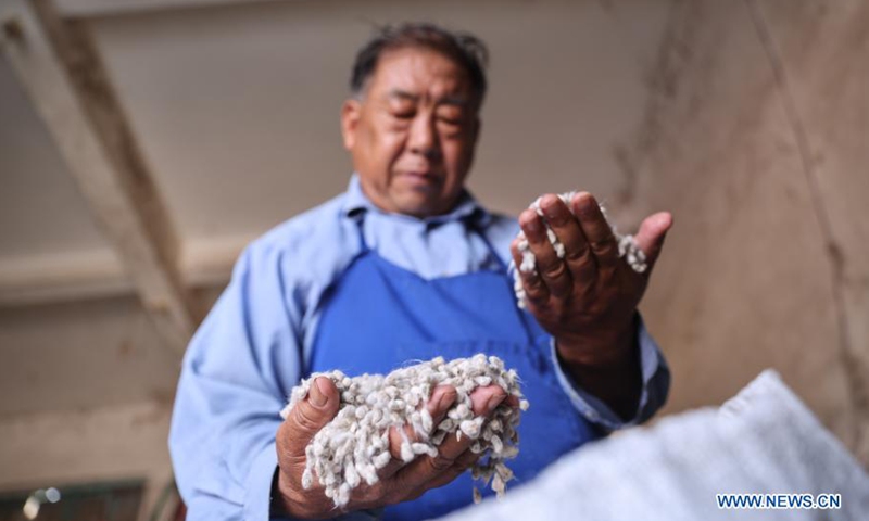 Zhao Guozhong checks cotton seeds in a warehouse at Nanfan breeding base in Sanya, south China's Hainan Province, Feb. 28, 2021. Zhao Guozhong, who has spent 43 Spring Festivals at Nanfan breeding base as an expert on cotton breeding, started every morning of his days in Sanya by dashing to the field to pollinate cotton plants and to observe their growth under the scorching sun.Photo:Xinhua