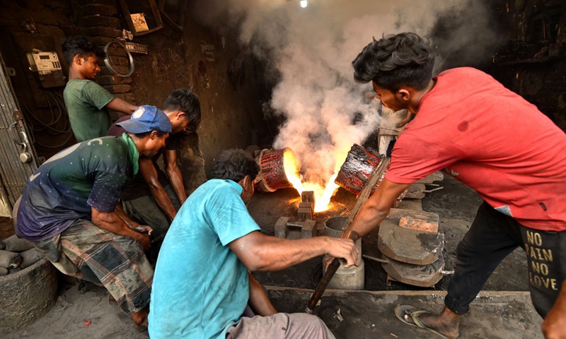 Workers pour molten metal into a mold at a dockyard in Keraniganj on the outskirts of Dhaka, Bangladesh, on March 1, 2021. (Photo: Xinhua)