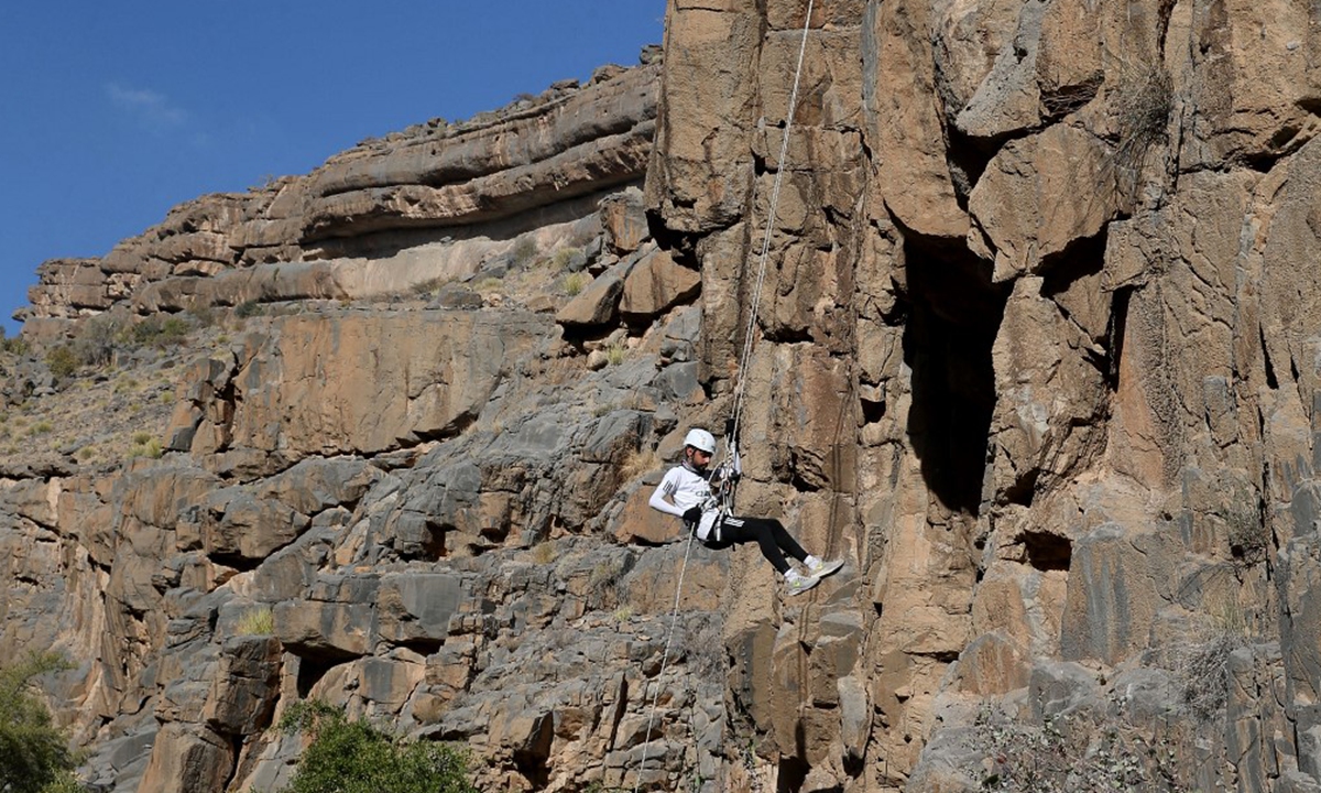 Haitham al-Abri rappels down a mountain in the village of Misfat al-Abriyeen situated on the escarpments of Oman's Grand Canyon, on February 8. Photo: AFP