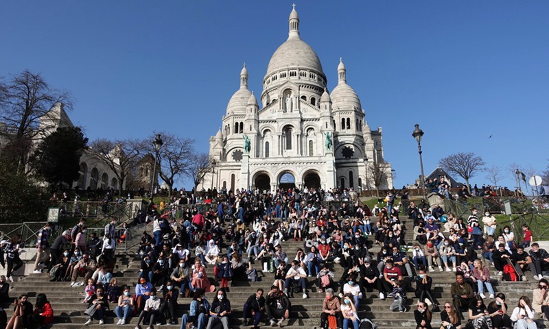 People enjoy the sunshine in front of the Sacre Coeur Basilica atop the Montmartre in Paris, France, Feb. 24, 2021.(Photo: Xinhua)