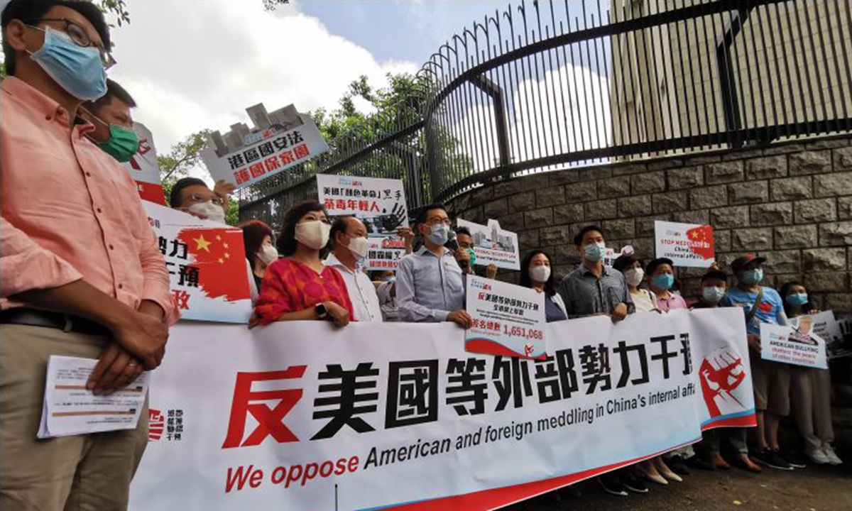 Hong Kong residents hold banners opposing the US and foreign meddling in China's internal affairs in front of the US Consulate General in Hong Kong on July 2, 2020.