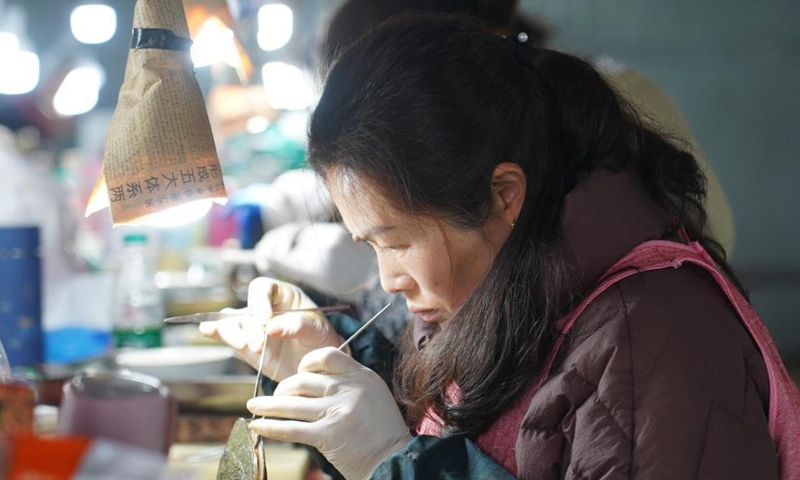 A worker inserts a nucleus into a mussel to form a pearl in a cultivation base in Tajiang Village of Wannian County, east China's Jiangxi Province, March 3, 2021. Photo:Xinhua