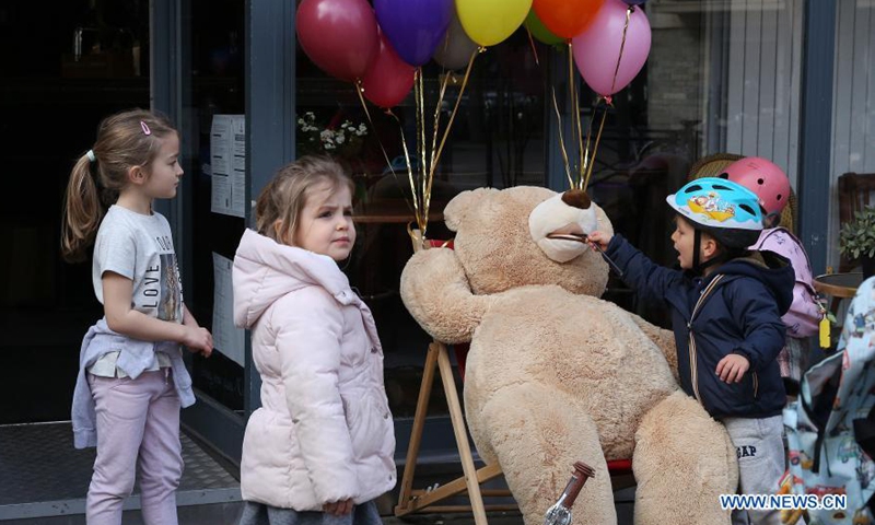 Children play with a giant teddy bear outside a restaurant in Paris, France, March 3, 2021. Giant teddy bears are seen at a restaurant which offers take away services in Paris. Restaurants, bars and cafes haved been all forced to shut down when the country entered into its second lockdown on Oct. 30, 2020. Photo:Xinhua