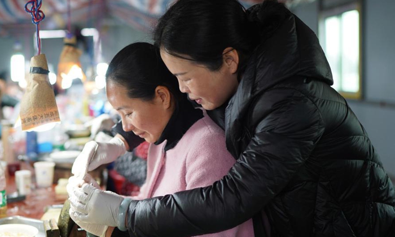 A worker gets trained to insert a nucleus into a mussel to form a pearl in a cultivation base in Tajiang Village of Wannian County, east China's Jiangxi Province, March 3, 2021.  Photo:Xinhua