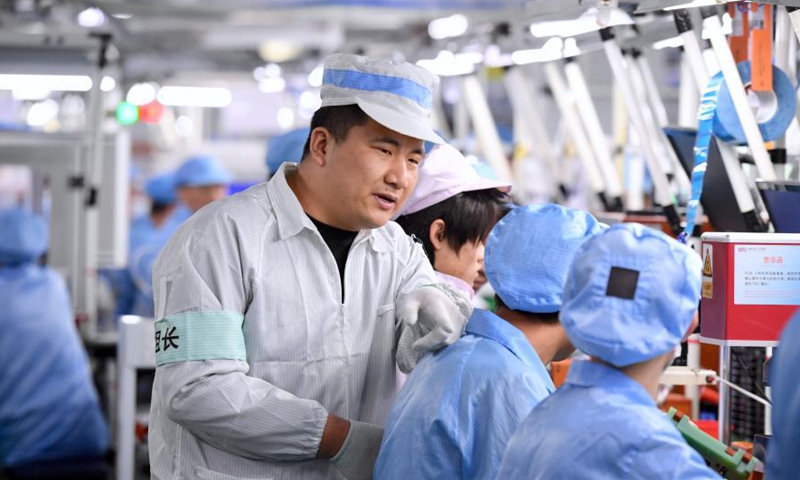 Chen Manku, a production line foreman from northwest China's Ningxia Hui Autonomous Region, guides workers at a workshop in Fuzhou, southeast China's Fujian Province, Feb. 3, 2021. Photo:Xinhua