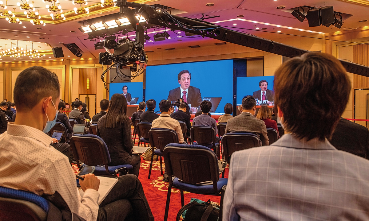 Zhang Yesui, spokesperson for the fourth session of the 13th National People's Congress (NPC) is seen on the screens as he speaks during an online press conference, in Beijing on Thursday.  Photo: IC