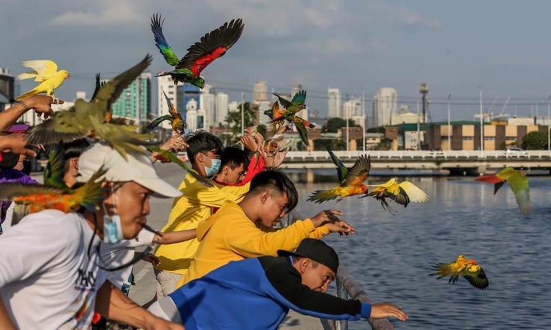 Members of the Manila All-Star Free Flight, a group of avian enthusiasts, train their pet parrots to fly during a free flight activity in Manila, the Philippines on March 7, 2021. Manila All-Star Free Flight aims to teach pet parrots the freedom of flight for their pet's mental and physical health. (Xinhua/Rouelle Umali)