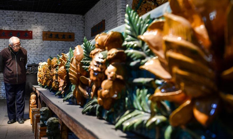 Ge Yuansheng observes colored glaze handicrafts in his workshop in Taiyuan, north China's Shanxi Province, March 3, 2021. Photo:Xinhua