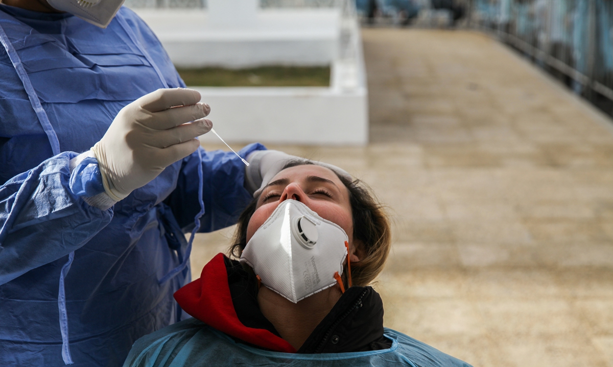A medic collects samples from a woman for COVID-19 tests in the street of Ariana governorate which is located 6 km from the capital Tunis, on January 8, 2021 during a Mass COVID-19 Testing which has been launched by the local authorities in bid to contain and slow down the spread of coronavirus pandemic. Photo: VCG