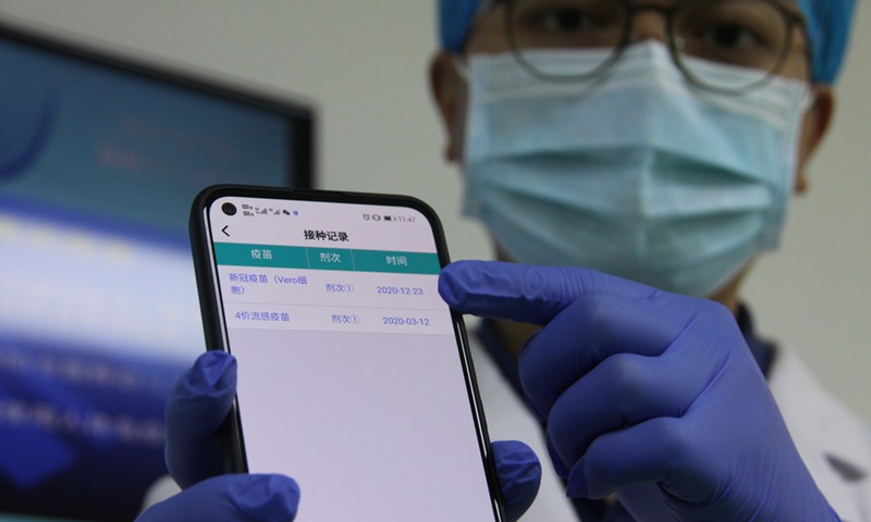 A medical worker shows his COVID-19 vaccination records on a phone app developed by the provincial center for disease control and prevention, at the health management center in Panyu District of Guangzhou City, south China's Guangdong Province, Jan. 6, 2021.(Photo: Xinhua)