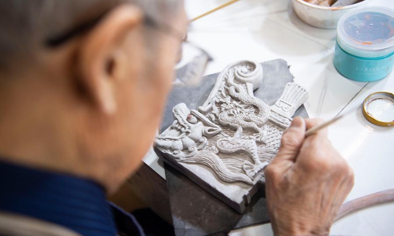 Ge Yuansheng works on a colored glaze handicraft in his workshop in Taiyuan, north China's Shanxi Province, Feb. 3, 2021. Photo:Xinhua