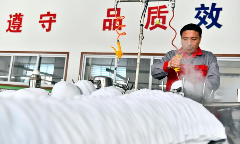 A worker makes hats at a manufacturing shop in Ligezhuang Town in Jiaozhou, east China's Shandong Province, March 4, 2021. Over the past 30 years, Ligezhuang Town, a major manufacturing base and collecting and distributing center featuring hat-related products, has achieved industrial upgrading, providing one-stop service for buyers worldwide.Photo:Xinhua