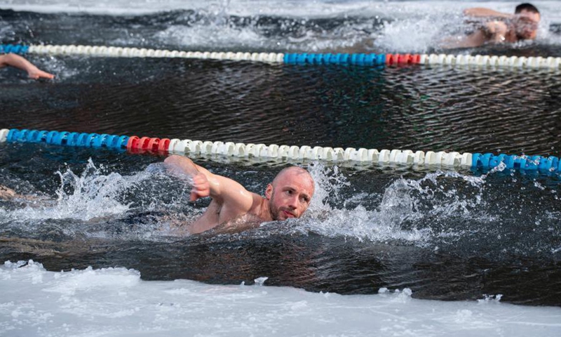 A swimmer takes part in a winter swimming race on the Green Lake in Vilnius, Lithuania, on March 6, 2021. A 25-meter winter swimming race was held here on Saturday.Photo:Xinhua