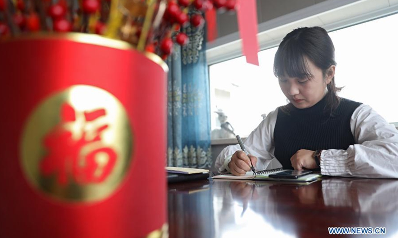 Yan Jiaxin calculates the materials needed to make handicraft goods in Qiaotuo Village of Tai'an County, Anshan, northeast China's Liaoning Province, March 5, 2021. Yan Jiaxin is a household name in her hometown Qiaotuo Village, because the 21-year-old entrepreneur has been running a handicraft factory which employs local women and sells products to European markets.Photo:Xinhua
