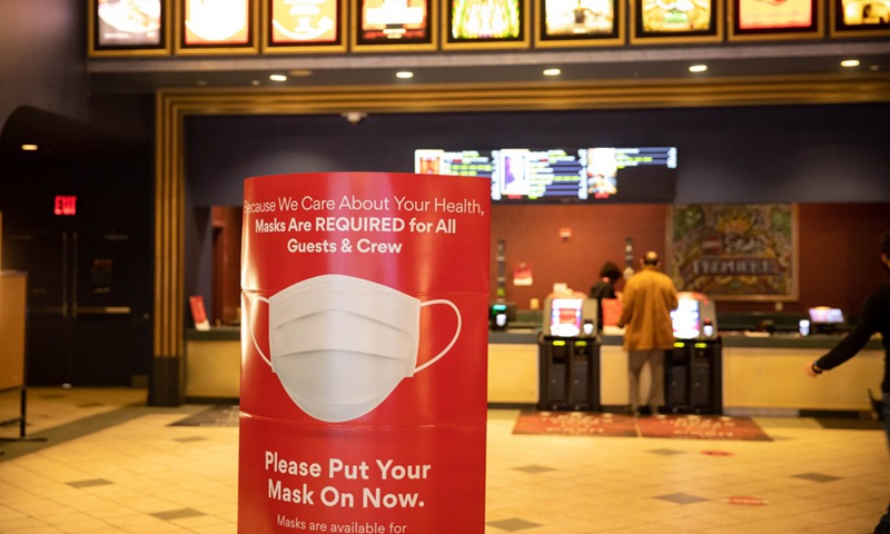 A sign of face mask requirements is seen at a movie theater in New York, the United States, March 5, 2021.(Photo: Xinhua)