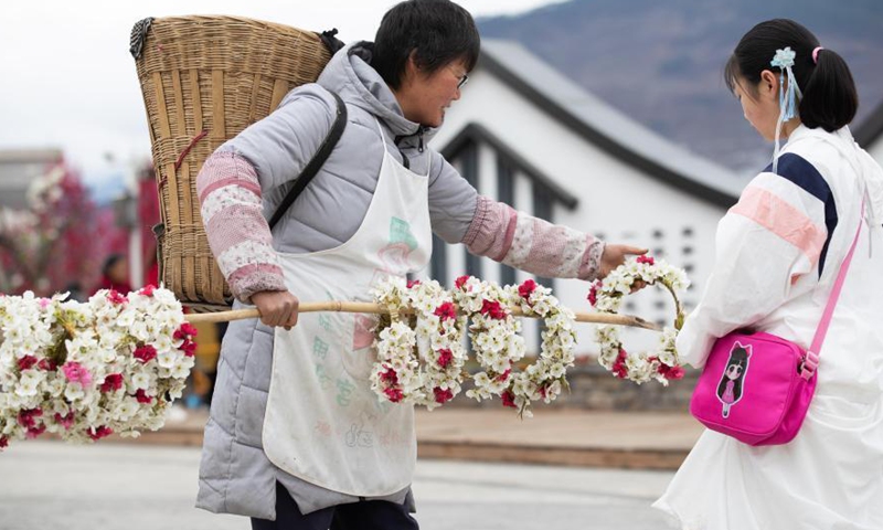 A vendor sells pear and peach flower wreaths in Sanqiang Village of Jiuxiang Township, Hanyuan County, southwest China's Sichuan Province, March 6, 2021.Photo:Xinhua