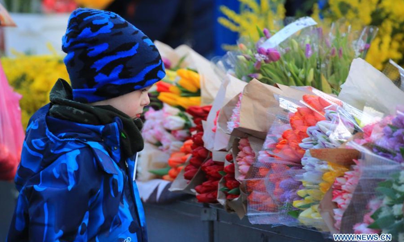 A child watches flowers at a flower market in Minsk, Belarus, March 6, 2021.(Photo: Xinhua)