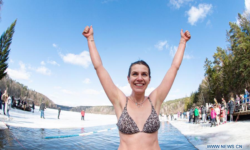 A swimmer reacts as she takes part in a winter swimming race on the Green Lake in Vilnius, Lithuania, on March 6, 2021. A 25-meter winter swimming race was held here on Saturday.Photo:Xinhua