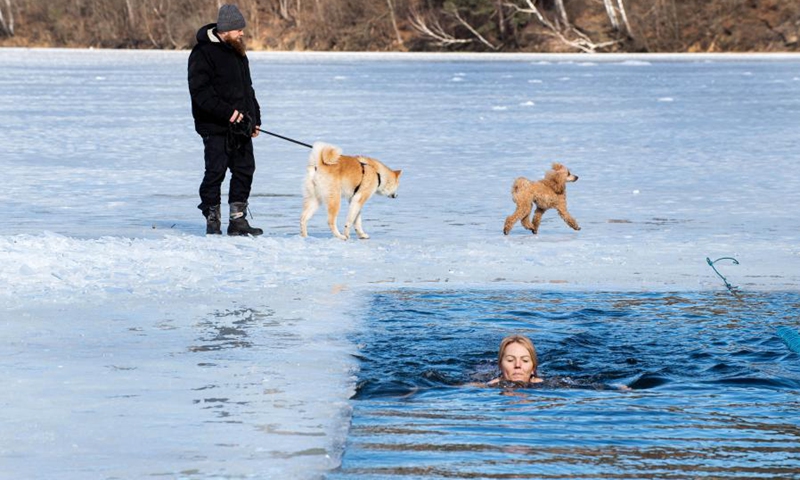 A swimmer takes part in a winter swimming race on the Green Lake in Vilnius, Lithuania, on March 6, 2021. A 25-meter winter swimming race was held here on Saturday.Photo:Xinhua