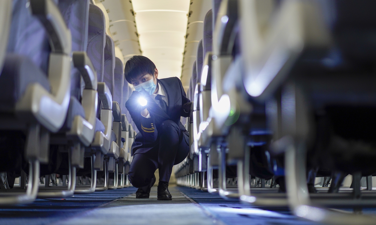 Liu Yao, a member of the China Express  in-flight security team, checks the cabin. 