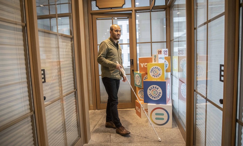 Kursat Ceylan demonstrates the use of the We Walk smart cane, which provides the blind people with navigation assistance via smart technologies, in Istanbul, Turkey on March 2, 2021.(Photo: Xinhua)