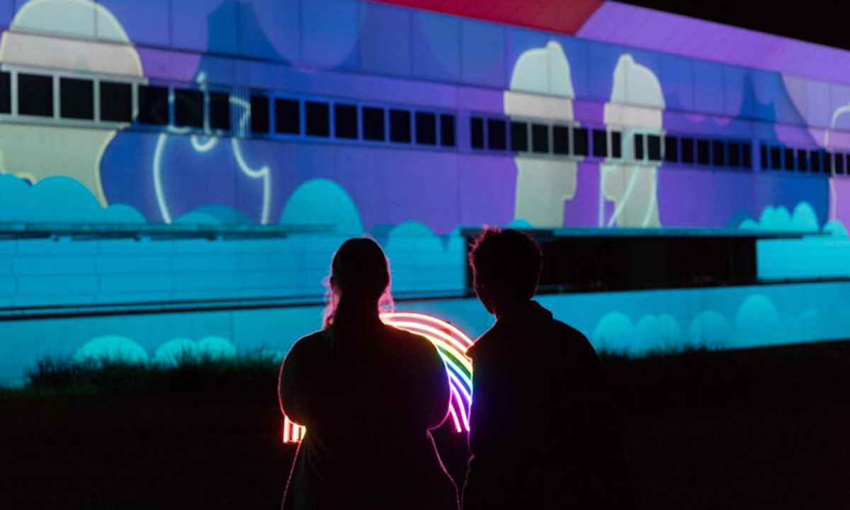 Photo taken on March 8, 2021 shows people enjoying the colorful lights during the Enlighten Festival in Canberra, Australia. The annual Enlighten Festival runs from Feb. 26 to March 8 in Canberra with landmark buildings illuminated with colorful lights. (Photo by Liu Changchang/Xinhua)