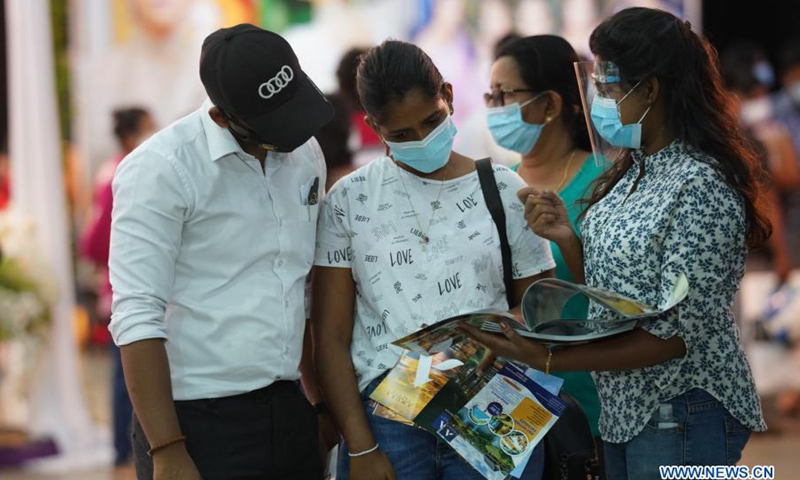 People wearing face masks talk during a wedding show in Colombo, Sri Lanka, on March 7, 2021. The three-day exhibition which covers all areas of the bridal industry concluded here on Sunday.(Photo: Xinhua)