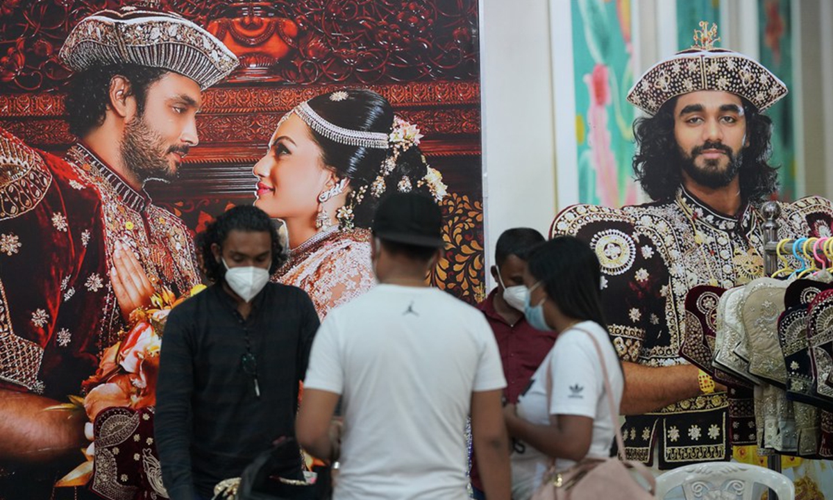 People wearing face masks talk during a wedding show in Colombo, Sri Lanka, on March 7, 2021. (Xinhua/Tang Lu)