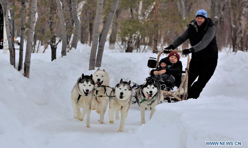 Local residents take a ride on a dog sled at the Central Park in Nur-Sultan, Kazakhstan, March 7, 2021. People on Monday celebrated the International Women's Day with a variety of entertainments at the Central Park.Photo:Xinhua