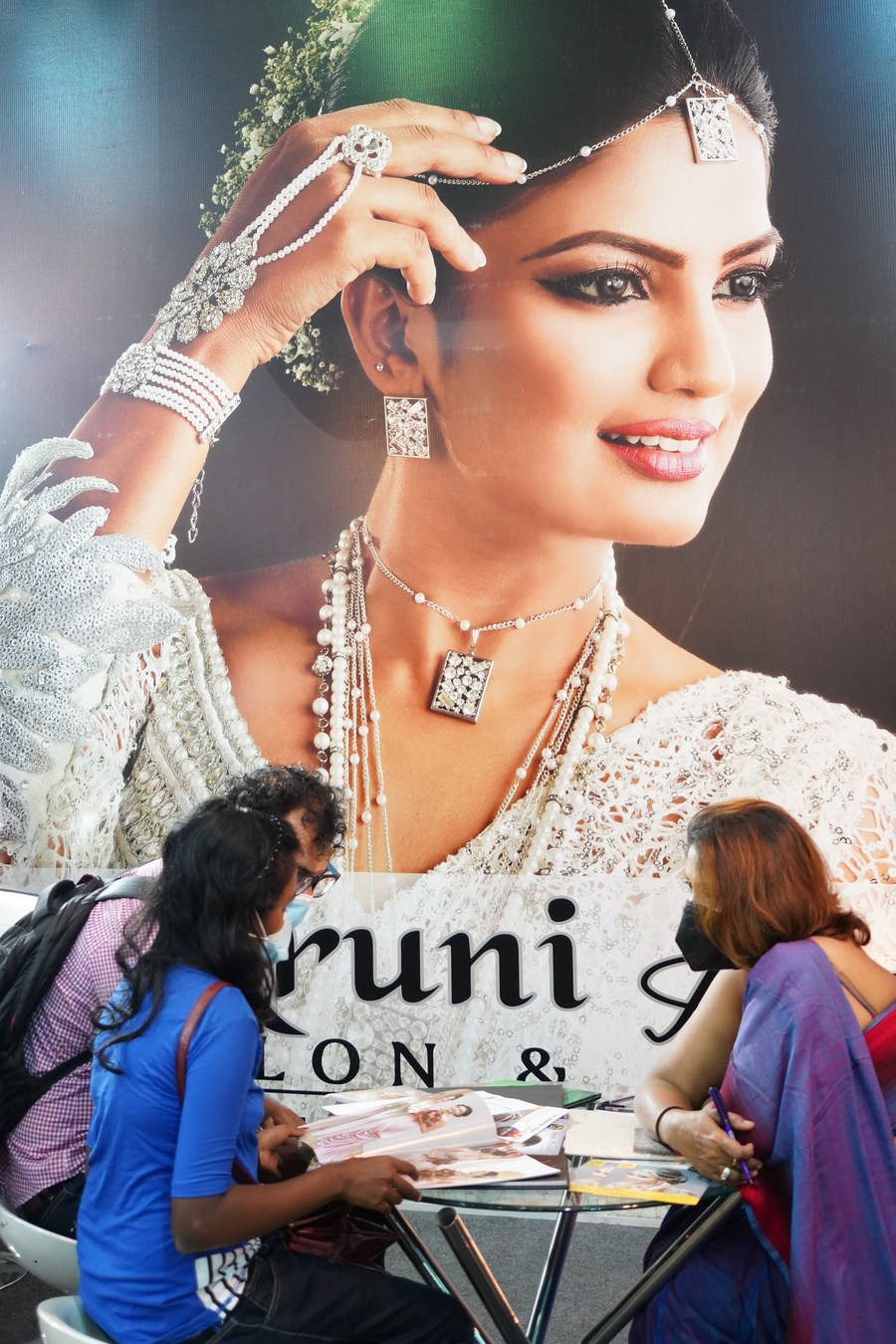 People wearing face masks talk during a wedding show in Colombo, Sri Lanka, on March 7, 2021. (Xinhua/Tang Lu)