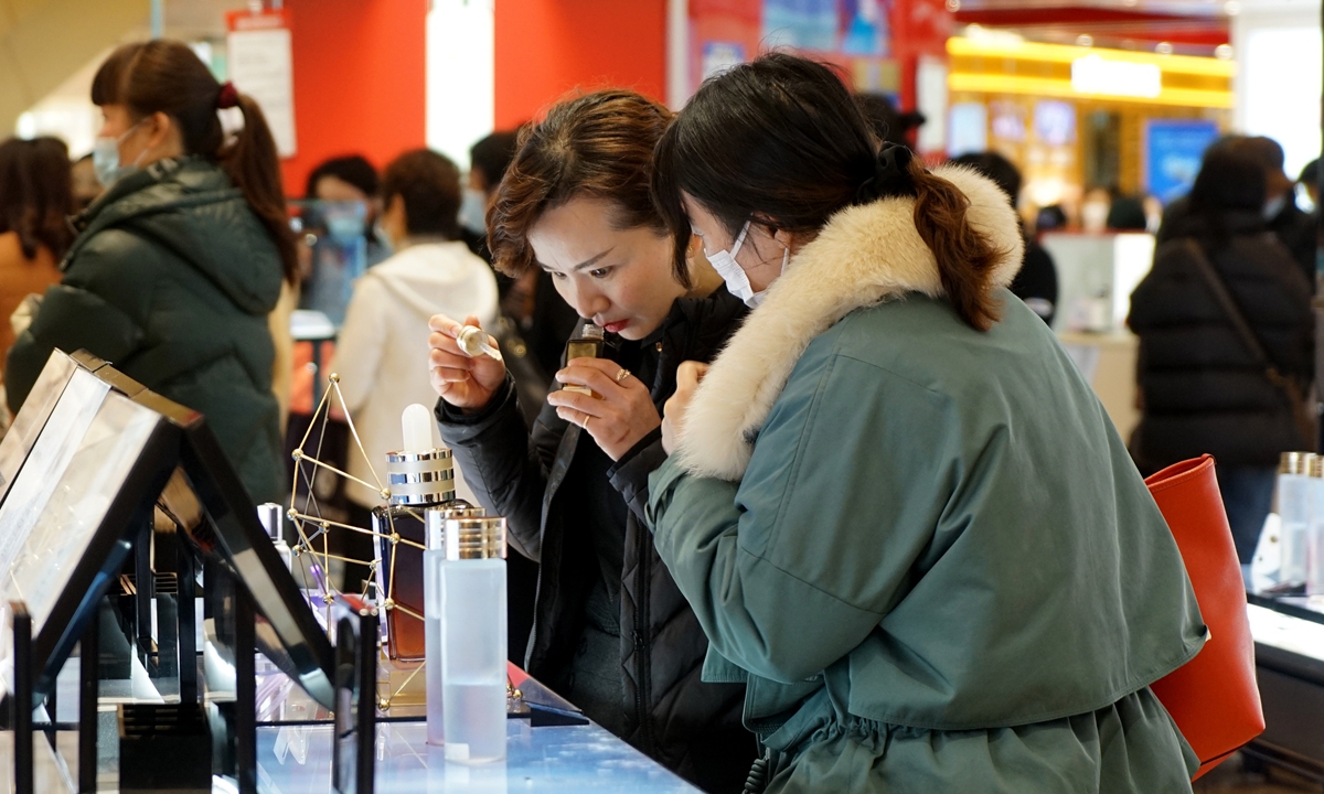 Two women try on cosmetics in a shopping mall in Shanghai on Monday, which was International Women's Day. Many malls held promotions to honor women as well as boost sales to offset the impact of the COVID-19 pandemic. Photo: Yang Hui/GT
