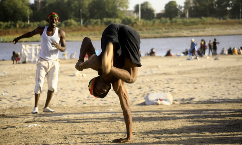 A man performs a gymnastic stunt on the beach of the Blue Nile in Khartoum, Sudan, March 5, 2021.(Photo: Xinhua)