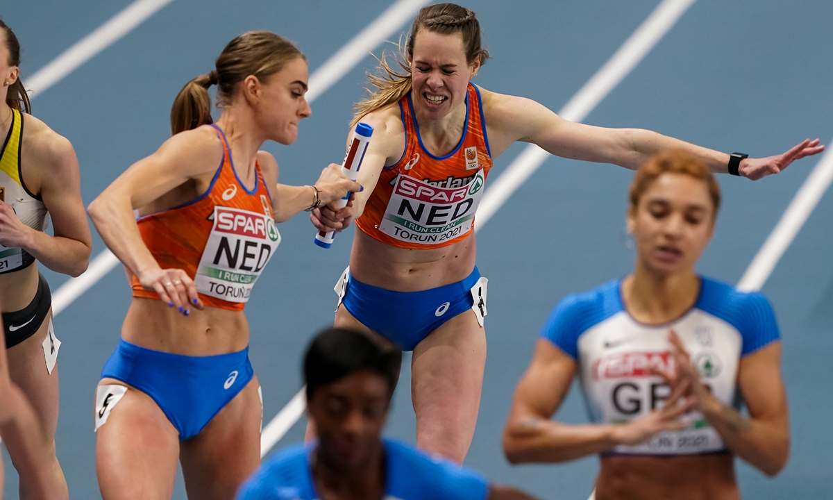 Lisanne de Witte of The Netherlands and Marit Dopheide of The Netherlands exchange sticks in the Women's 4x400m Relay final during the European Athletics Indoor Championships 2021 at Torun Arena on March 7, 2021 in Torun, Poland Photo: VCG