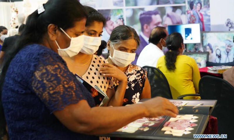 People wearing face masks look at wedding decorations during a wedding show in Colombo, Sri Lanka, on March 7, 2021. The three-day exhibition which covers all areas of the bridal industry concluded here on Sunday.(Photo: Xinhua)