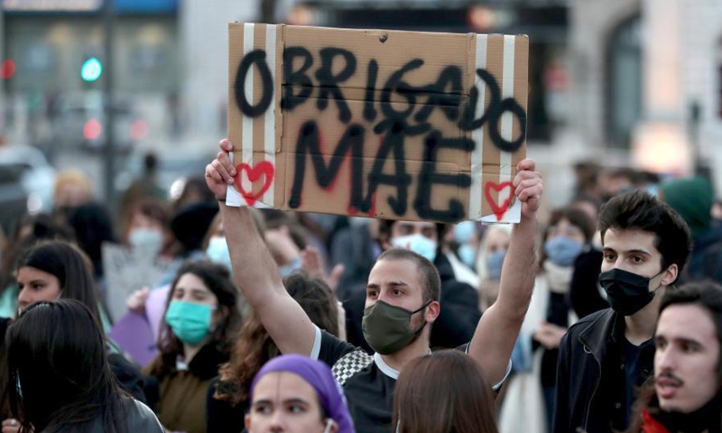 A man holding a signal reading Thank you mother takes part in a rally to mark the International Women's Day in downtown Lisbon, Portugal, on March 8, 2021.Photo:Xinhua