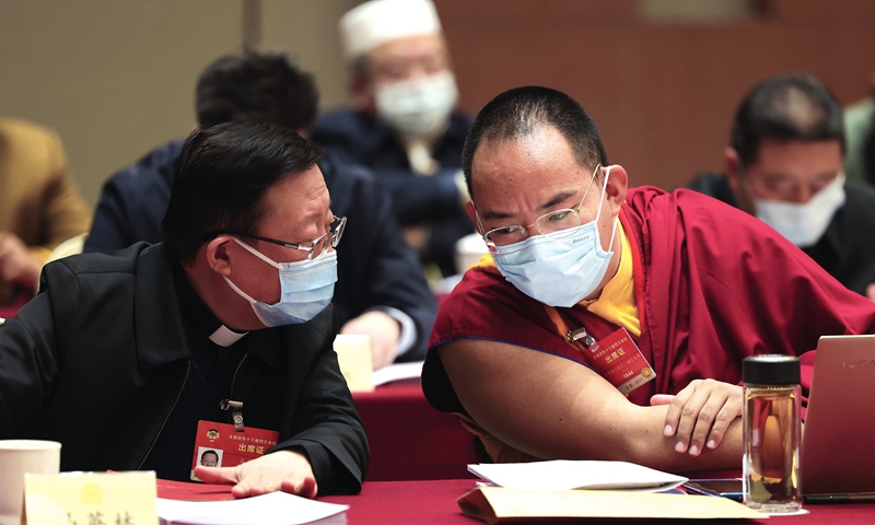 The 11th Panchen Lama Bainqen Erdini Qoigyijabu (right), a member of the Standing Committee of the Chinese People's Political Consultative Conference (CPPCC) National Committee, talks with Ma Yinglin, also a member of the Standing Committee of the CPPCC National Committee and head of the Bishops' Conference of the Catholic Church in China, on Tuesday, as the fourth session of the 13th CPPCC National Committee discusses the work reports of the country's top court and procuratorate authorities.  Photo: cnsphoto