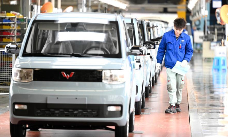A worker checks new energy vehicles in Liuzhou, south China's Guangxi Zhuang Autonomous Region, March 8, 2021. Liuzhou is a famous automobile industrial base. In recent years, local new energy automobile industry has seen vigorous development. Photo:Xinhua