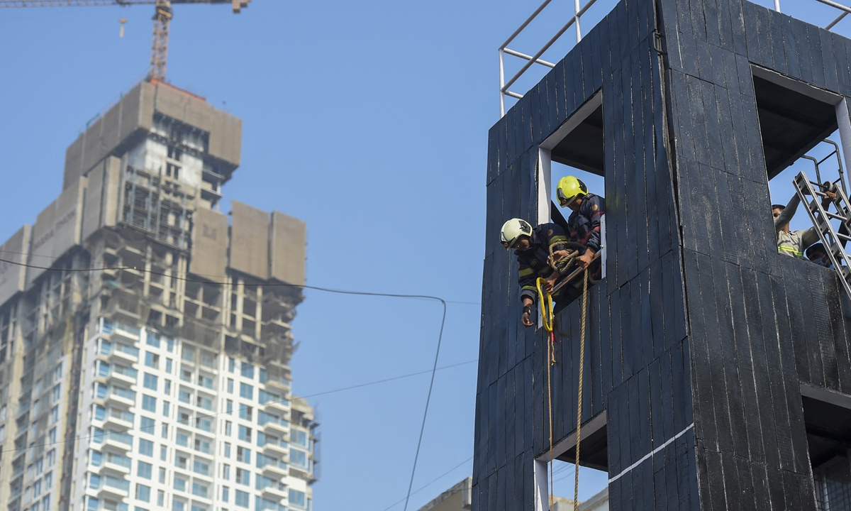 Firefighters take part in a fire drill competition in Mumbai, India on Tuesday. On Monday evening, nine emergency responders have died while dousing a fire that broke out on the 13th floor of the New Koilaghat building in Kolkata. Photo: AFP