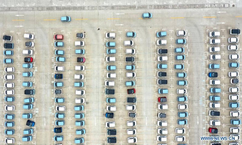 Aerial photo taken on March 8, 2021 shows workers driving new energy vehicles out of a parking lot at a logistics park in Liuzhou, south China's Guangxi Zhuang Autonomous Region. Liuzhou is a famous automobile industrial base. In recent years, local new energy automobile industry has seen vigorous development.Photo:Xinhua