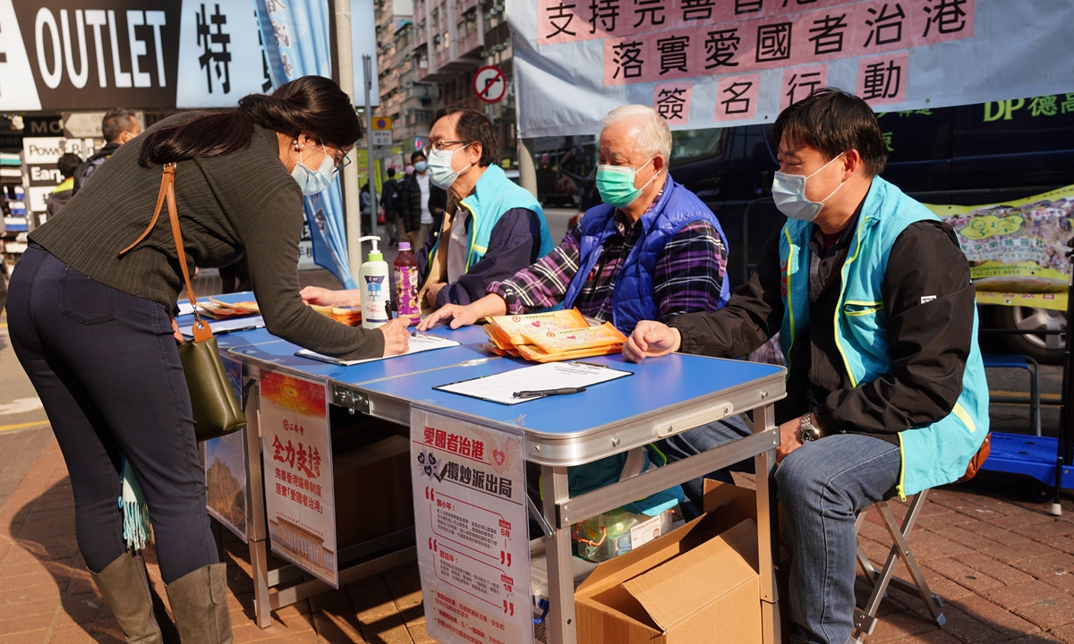 Hong Kong residents sign their names in support of improving the city's electoral system at a post set up by the Hong Kong Federation of Trade Unions, a Hong Kong local labor and political group established in 1948, on Tuesday. 
Photo: cnsphoto